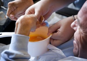 A student breaking eggs for a chicken pie