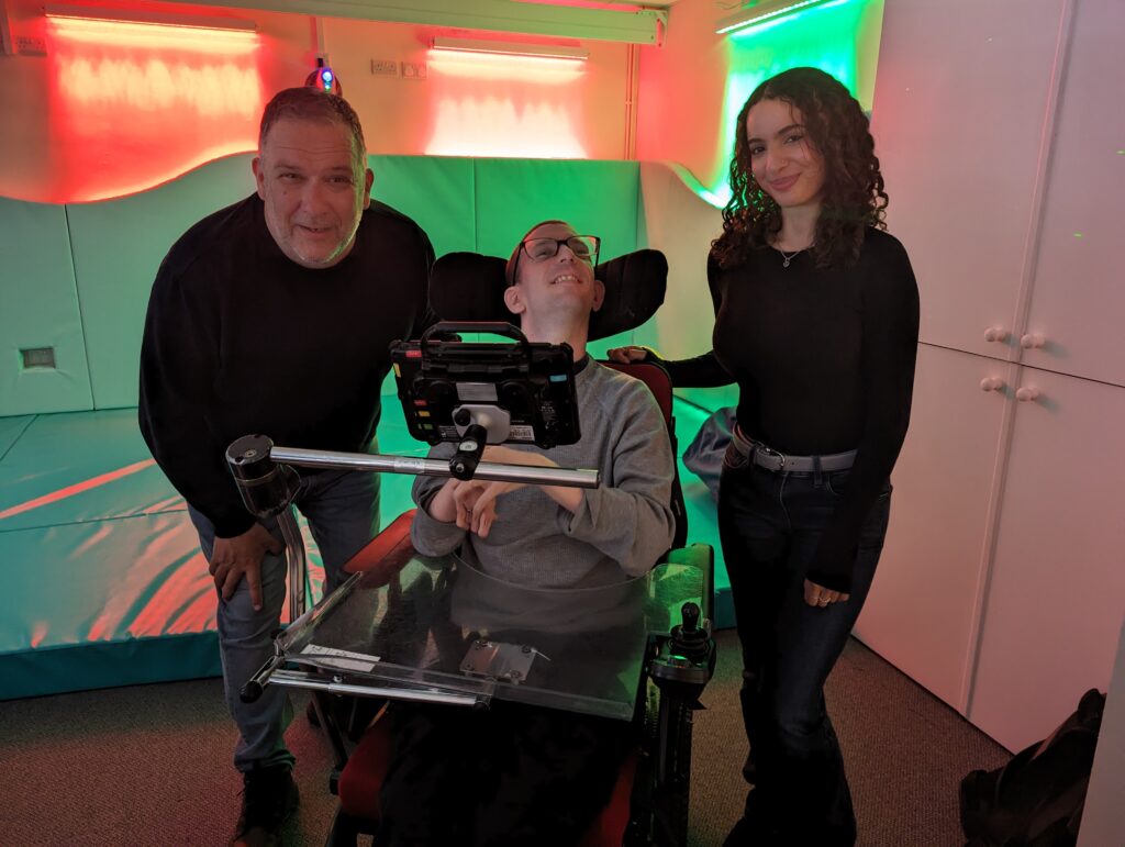 Three people smiling at the camera with the new sensory space in the background